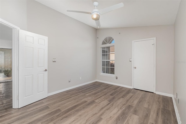 spare room featuring vaulted ceiling, ceiling fan, baseboards, and wood finished floors