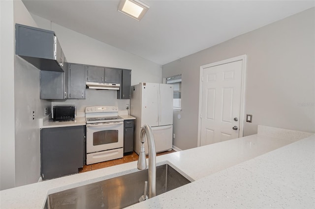 kitchen with lofted ceiling, white appliances, under cabinet range hood, and light countertops