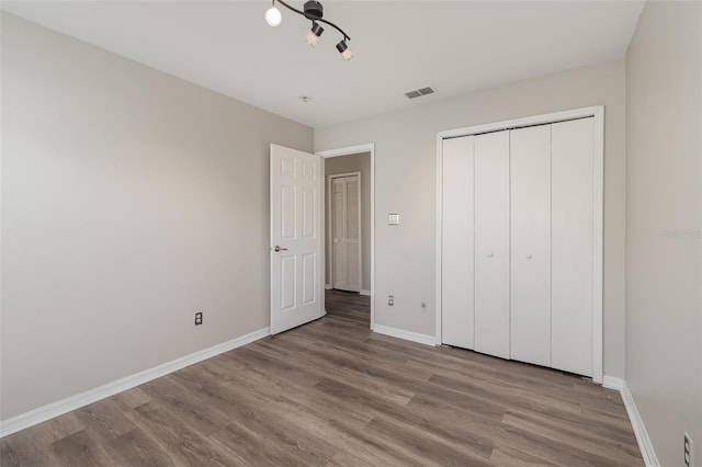 unfurnished bedroom with light wood-style floors, visible vents, and baseboards