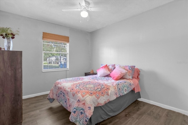 bedroom featuring a textured ceiling, ceiling fan, and dark hardwood / wood-style floors