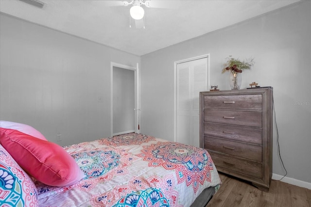 bedroom with ceiling fan, a closet, and wood-type flooring