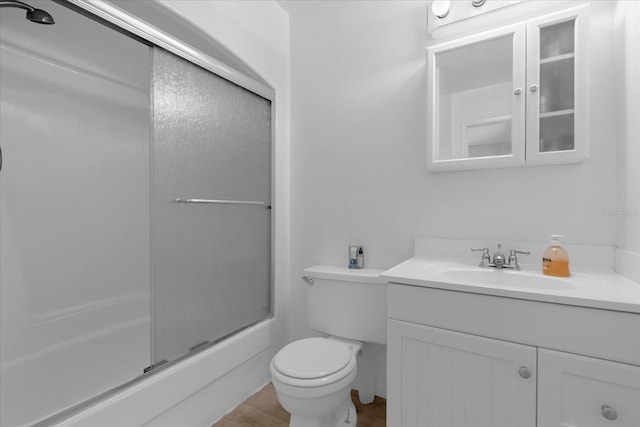 full bathroom featuring combined bath / shower with glass door, vanity, toilet, and hardwood / wood-style flooring