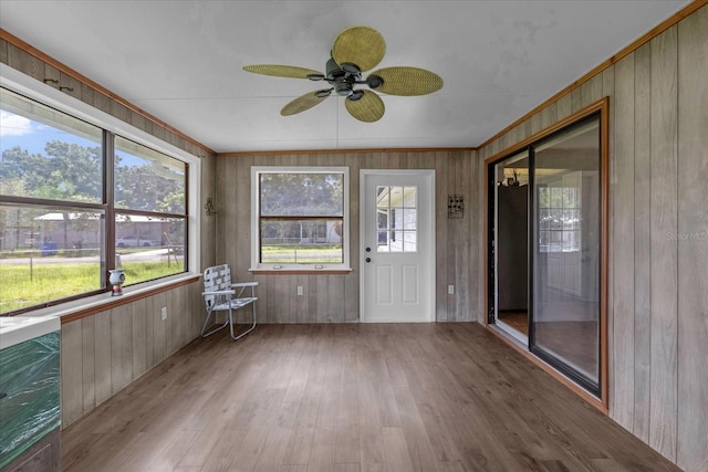 unfurnished sunroom featuring ceiling fan