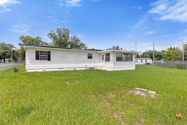 rear view of property with a lawn