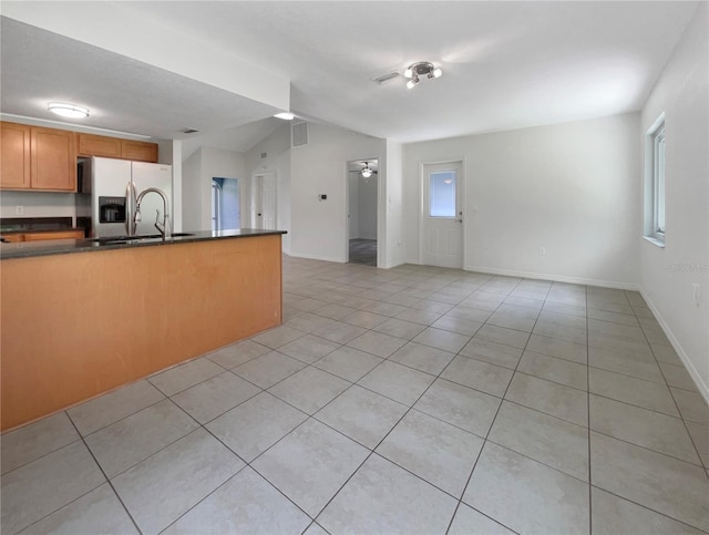 kitchen featuring stainless steel refrigerator with ice dispenser, light tile patterned floors, sink, and ceiling fan