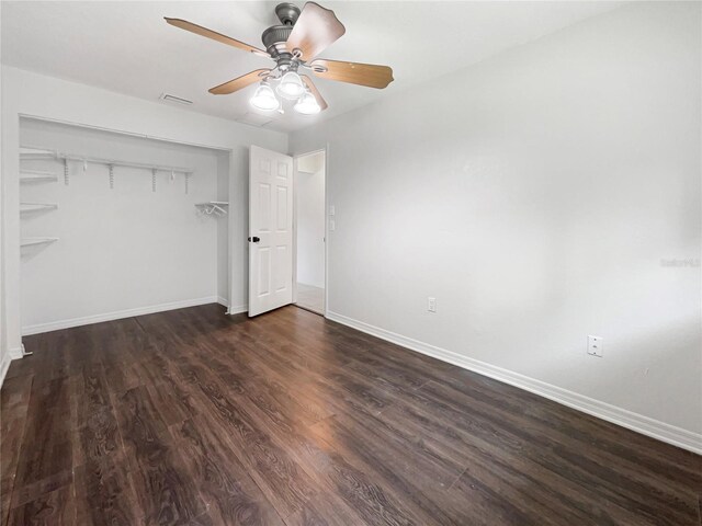 unfurnished bedroom with ceiling fan, wood finished floors, visible vents, baseboards, and a closet