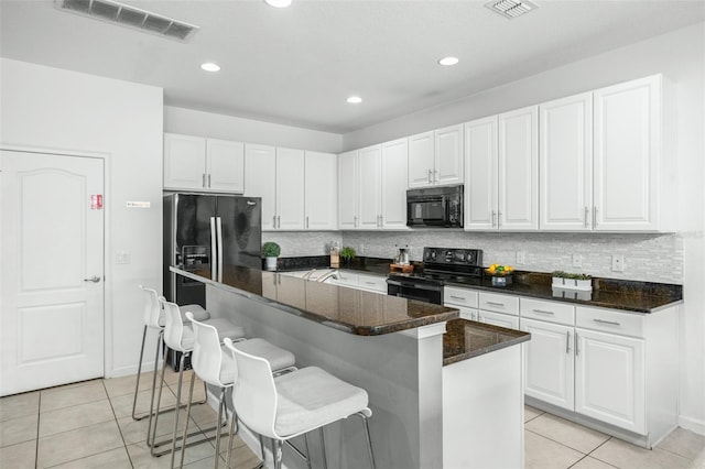 kitchen with black appliances, white cabinetry, and a kitchen island