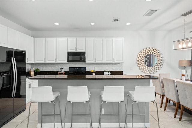 kitchen with light tile patterned floors, dark countertops, backsplash, and black appliances