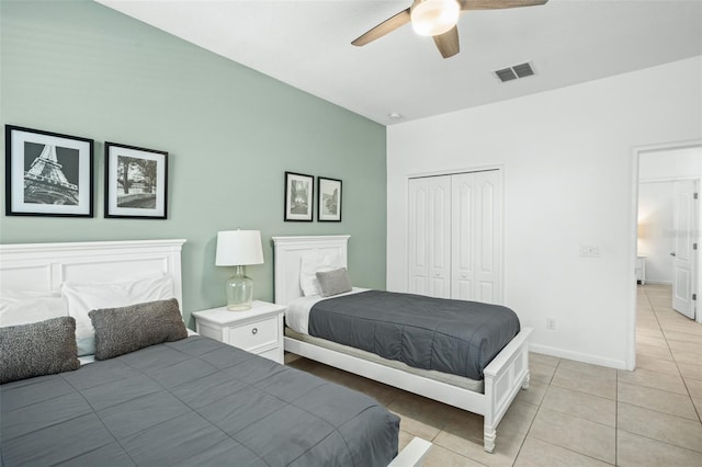 bedroom with visible vents, a closet, baseboards, a ceiling fan, and light tile patterned floors