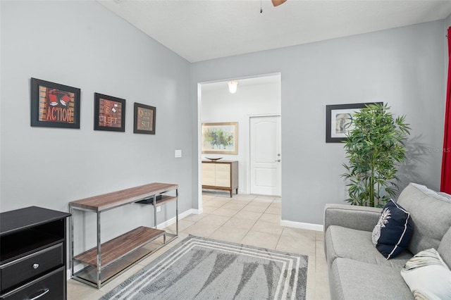 interior space featuring a ceiling fan, baseboards, and light tile patterned floors