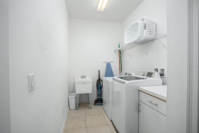 washroom featuring baseboards, laundry area, washing machine and dryer, and light tile patterned floors