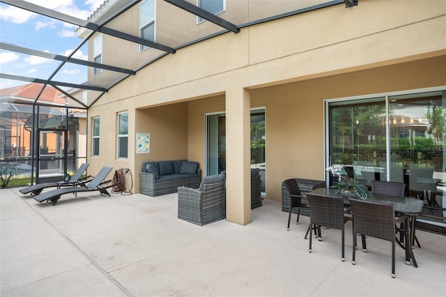 view of patio / terrace featuring outdoor dining space, glass enclosure, and outdoor lounge area