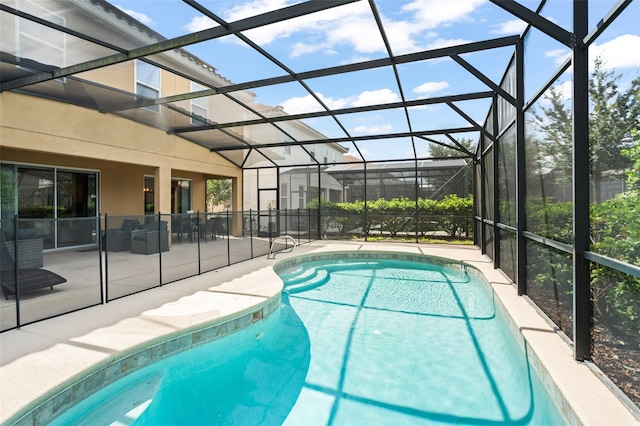 outdoor pool with glass enclosure and a patio
