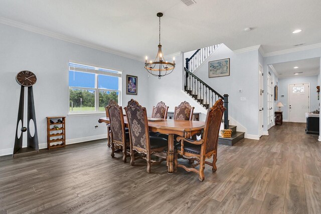 dining area with ornamental molding, dark wood-type flooring, and an inviting chandelier