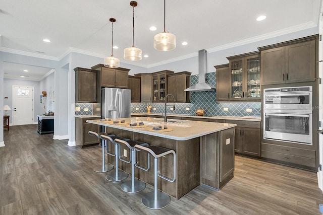 10472 Petrillo Way, Winter Garden, FL 34787 - kitchen with stainless steel appliances, dark brown cabinetry, wall chimney exhaust hood, and dark wood finished floors