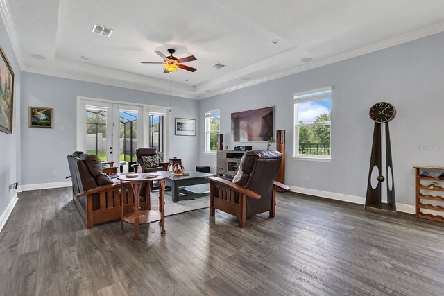 living room with crown molding, french doors, dark hardwood / wood-style flooring, a tray ceiling, and ceiling fan