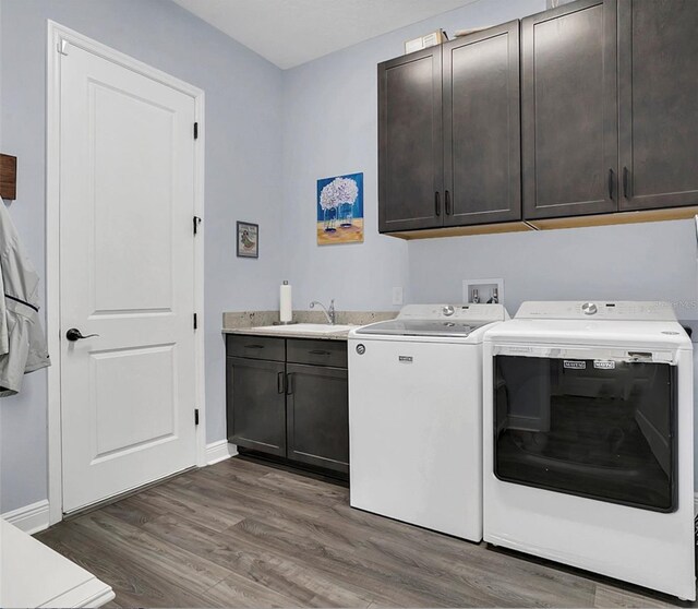 laundry area with washer and dryer, cabinets, sink, and dark wood-type flooring