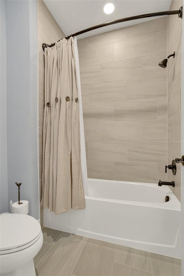 bathroom with tile patterned flooring, toilet, and shower / bath combo