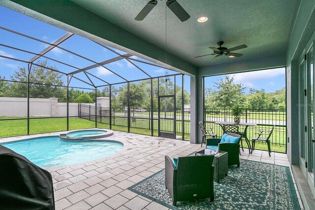 view of swimming pool featuring a lanai, ceiling fan, a patio area, and an in ground hot tub