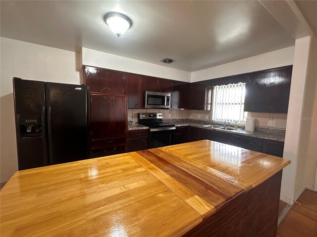 kitchen with stainless steel appliances, sink, and hardwood / wood-style flooring