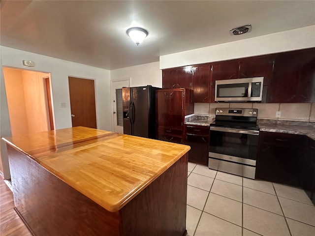 kitchen featuring appliances with stainless steel finishes and light hardwood / wood-style flooring