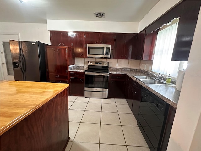 kitchen with black appliances, light tile patterned floors, and sink