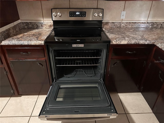 interior details with tile patterned flooring, stainless steel electric stove, and dark brown cabinetry