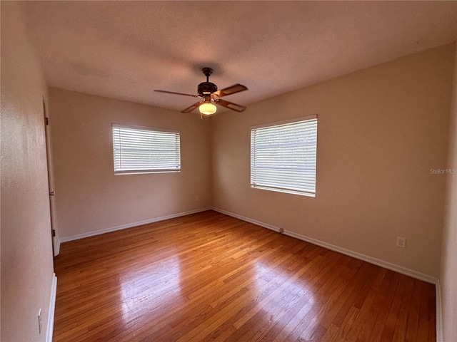 spare room with a textured ceiling, light hardwood / wood-style flooring, and ceiling fan