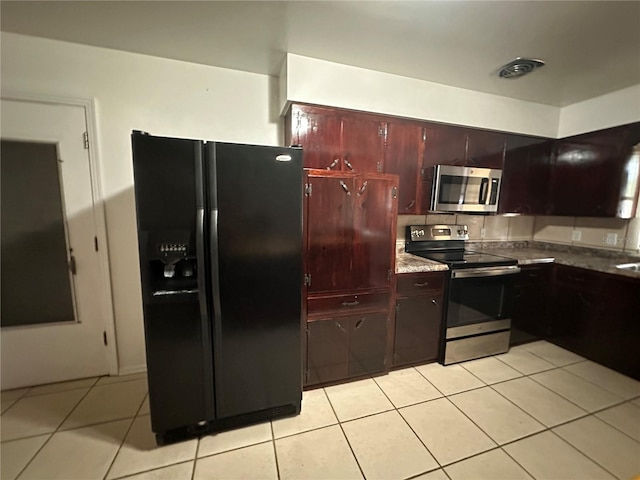 kitchen featuring backsplash, light tile patterned floors, and stainless steel appliances