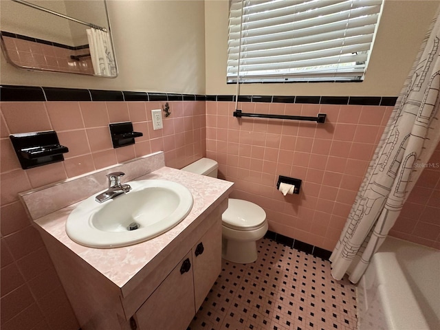 full bathroom with vanity, toilet, and tile walls