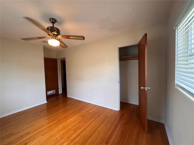 unfurnished bedroom featuring ceiling fan, a closet, and light wood-type flooring