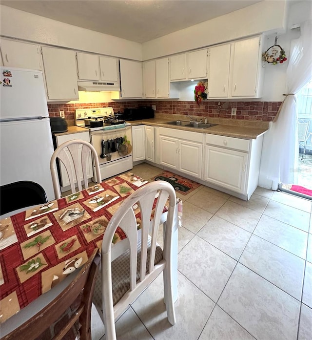 kitchen featuring white appliances, light tile patterned floors, tasteful backsplash, sink, and white cabinets