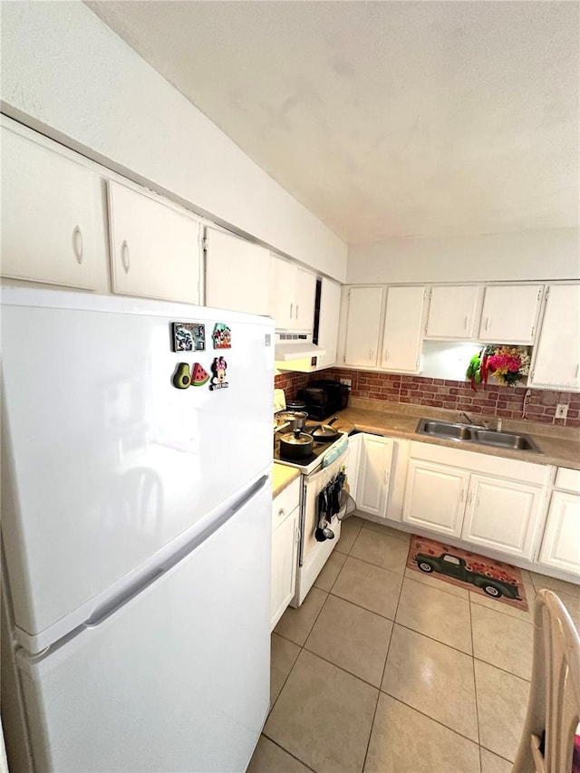 kitchen featuring light tile patterned floors, white appliances, white cabinetry, sink, and tasteful backsplash