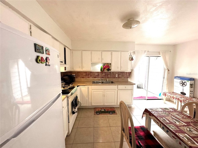 kitchen with backsplash, sink, white appliances, and white cabinetry