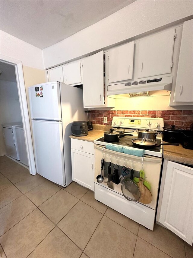 kitchen featuring white cabinets, white appliances, light tile patterned floors, and tasteful backsplash