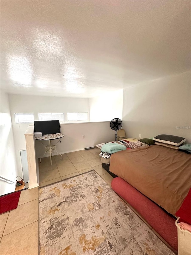 bedroom featuring light tile patterned floors and a textured ceiling