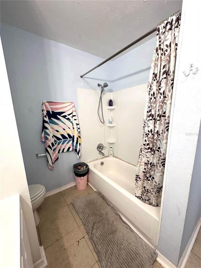 bathroom with a textured ceiling, toilet, tile patterned floors, and shower / bath combo