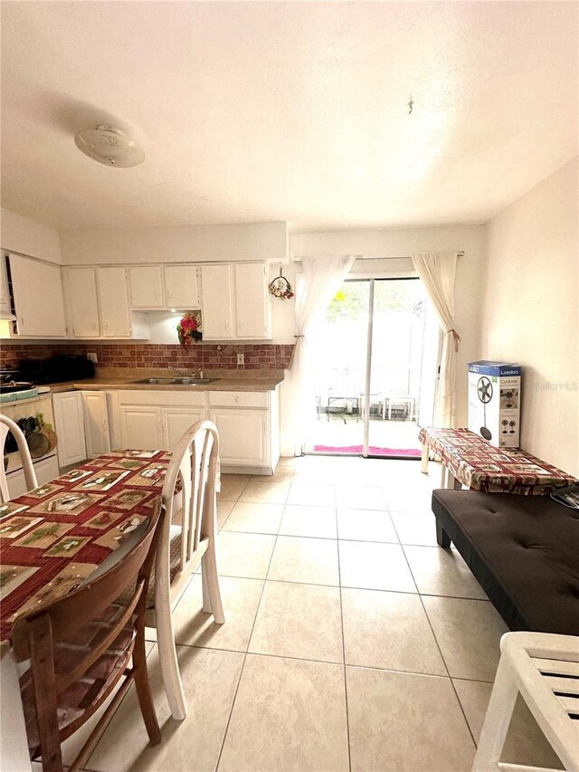 kitchen featuring sink, white cabinetry, and light tile patterned flooring