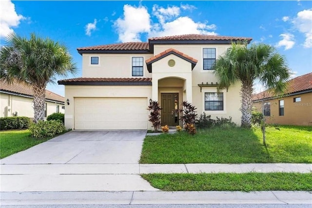 mediterranean / spanish home with a garage, driveway, a front yard, and stucco siding