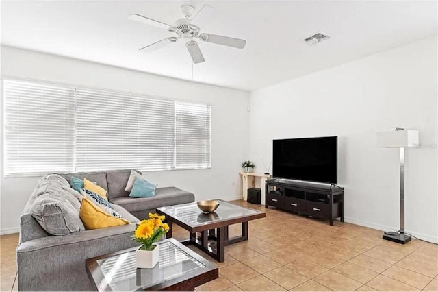 living room featuring light tile patterned floors, visible vents, baseboards, and ceiling fan