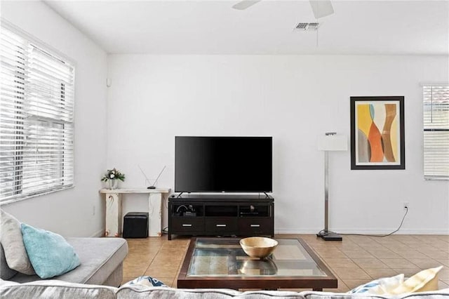 living room with tile patterned floors, a ceiling fan, and visible vents