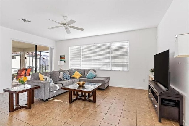 living room featuring light tile patterned flooring, a ceiling fan, visible vents, and baseboards