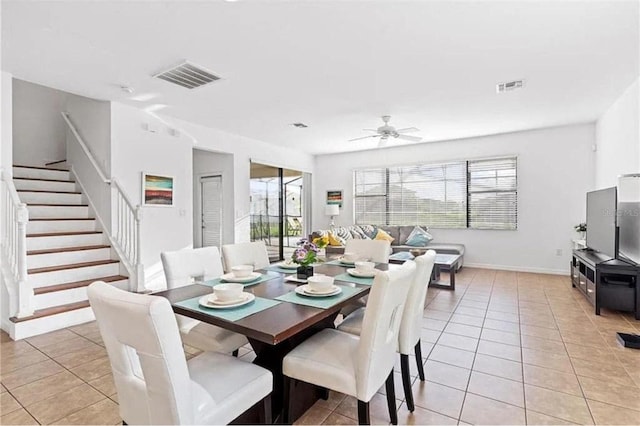 dining area featuring light tile patterned floors, visible vents, and stairway