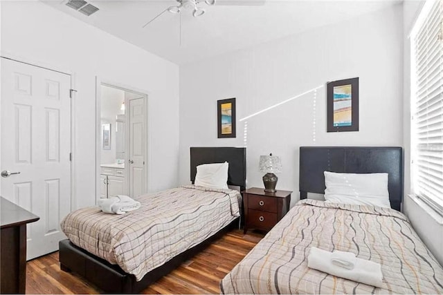 bedroom with visible vents, ensuite bath, a ceiling fan, and wood finished floors