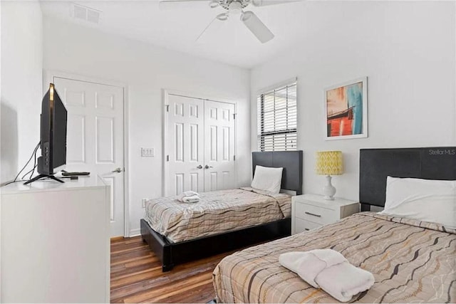 bedroom featuring a ceiling fan, wood finished floors, visible vents, and a closet