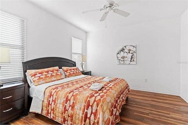 bedroom featuring baseboards, dark wood-style flooring, and ceiling fan