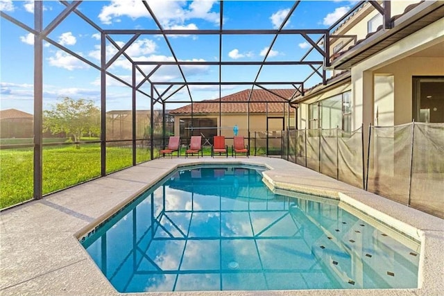 outdoor pool featuring a yard, glass enclosure, and a patio