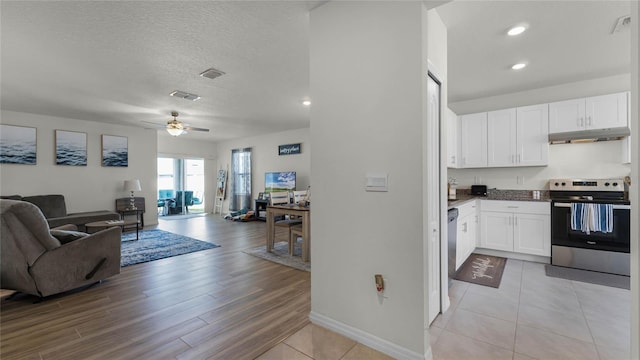 kitchen featuring appliances with stainless steel finishes, white cabinetry, light wood-type flooring, a textured ceiling, and ceiling fan