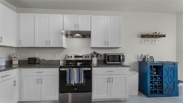 kitchen with white cabinets, a textured ceiling, appliances with stainless steel finishes, and light tile patterned floors