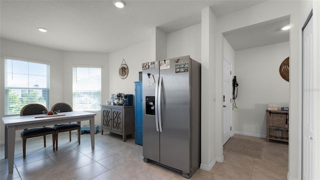 kitchen featuring light tile patterned flooring and stainless steel fridge with ice dispenser